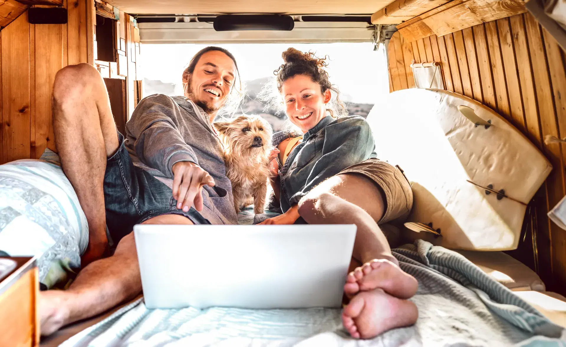 Couple in a van planning a trip on a laptop